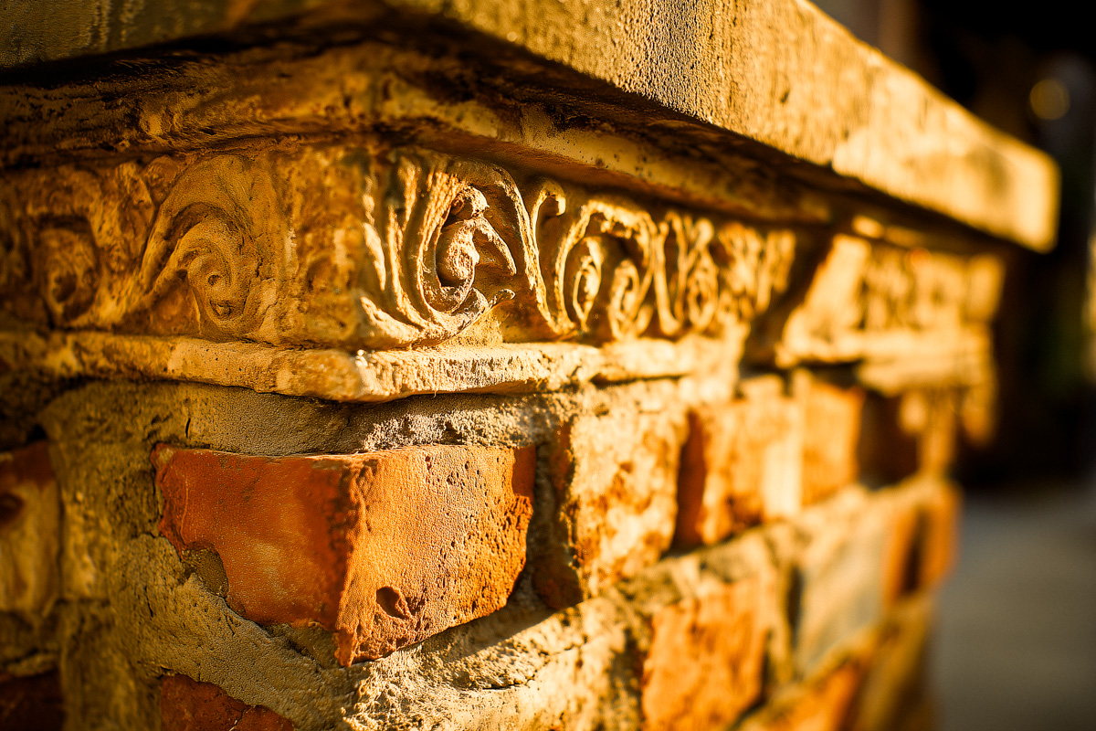 Close-up of ornamental carved stonework and aged brick on a historic building